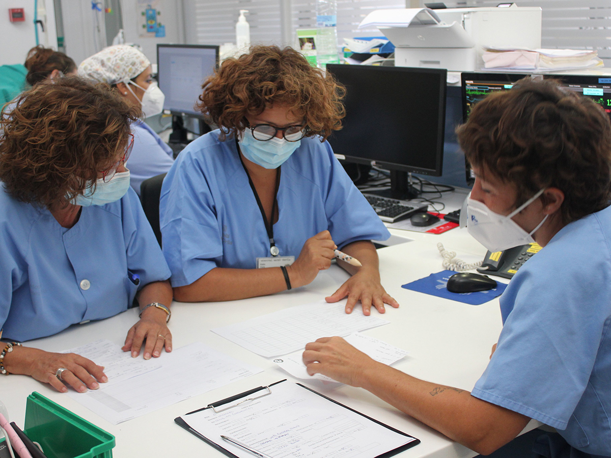 Grupo de enfermeras conversan y analizan documentación clínica
